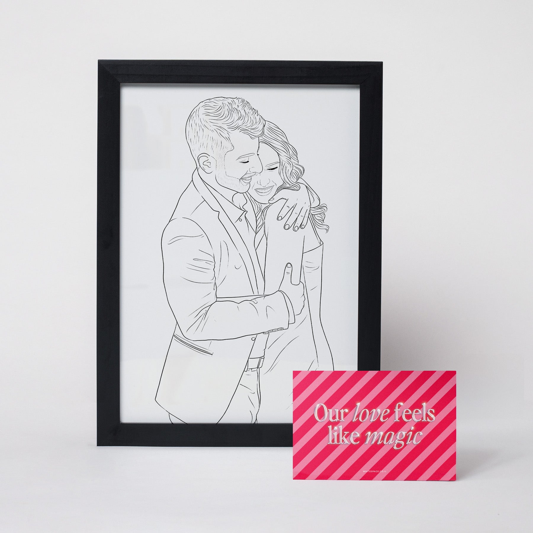 Digital line art illustration of a couple embracing, framed in a sleek black wooden frame, accompanied by a Valentine’s Day-themed card with the text ‘Our love feels like magic’ in pink and white stripes.